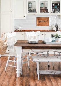 the kitchen table is set with white chairs and dishes on it's wooden top