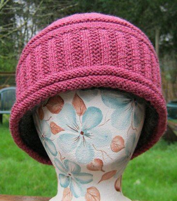 a mannequin's head wearing a pink knitted hat with flowers on it