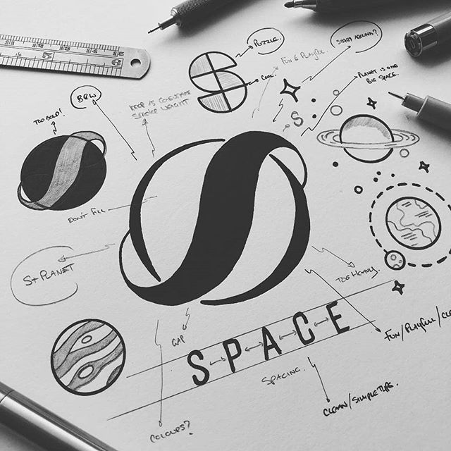 the space logo is surrounded by other doodles, pens and pencils on top of a sheet of paper