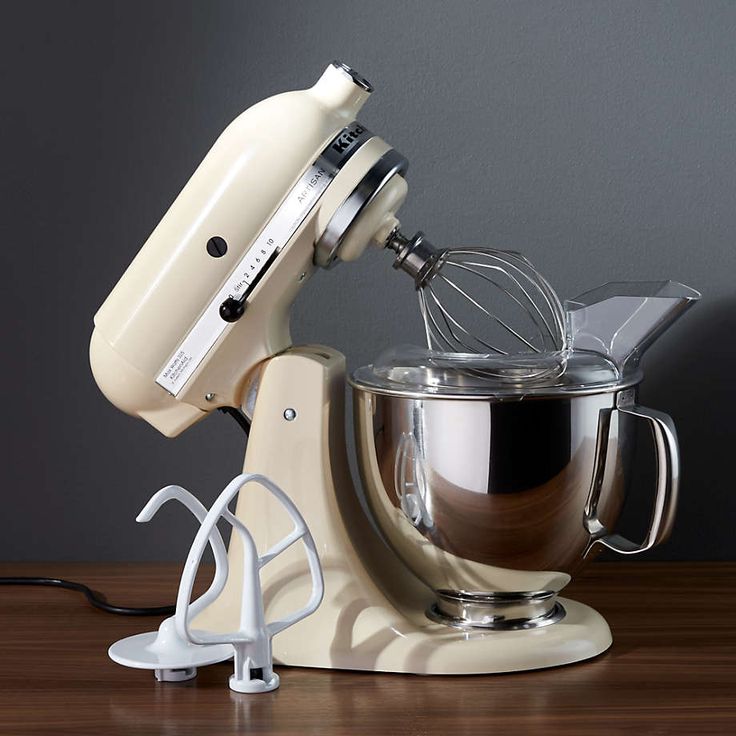 an electric mixer on a wooden table next to a wall