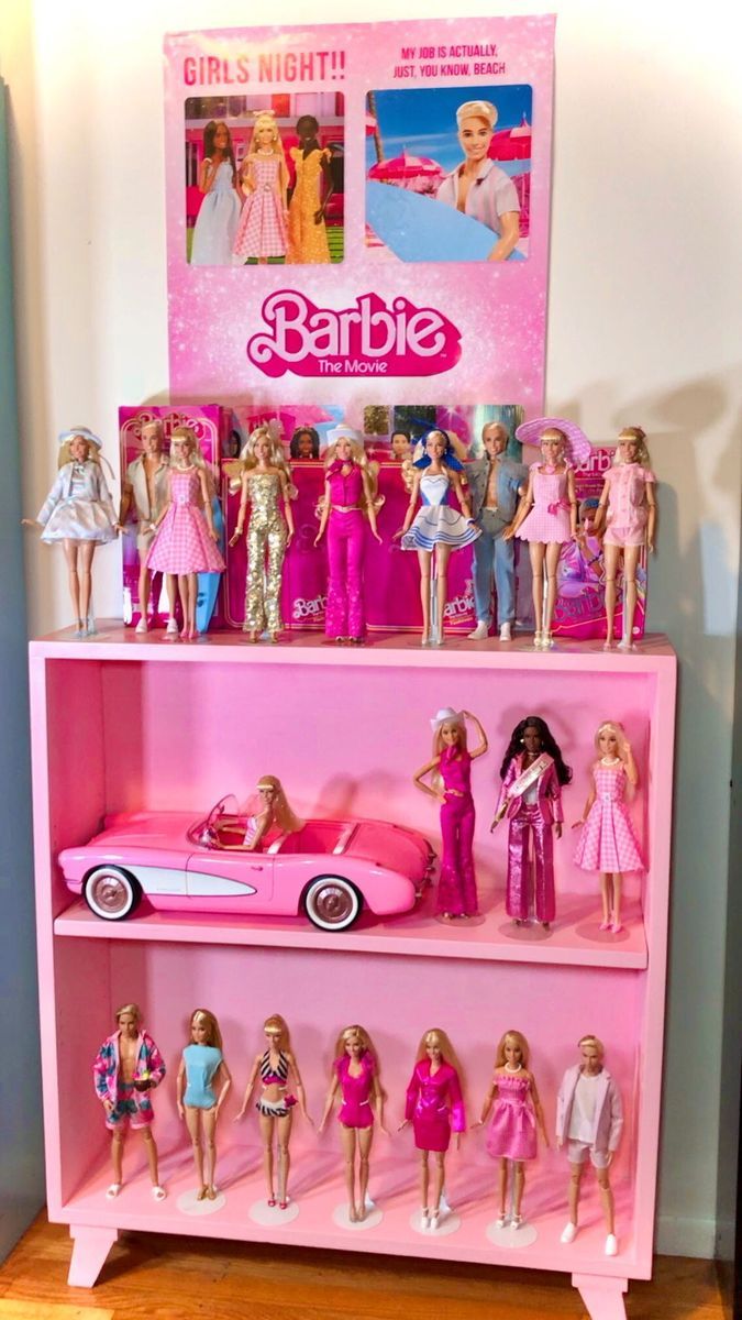 barbie dolls are lined up on top of a pink shelf