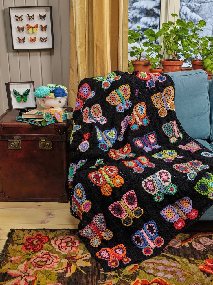 a living room with a blue couch covered in a black crocheted blanket