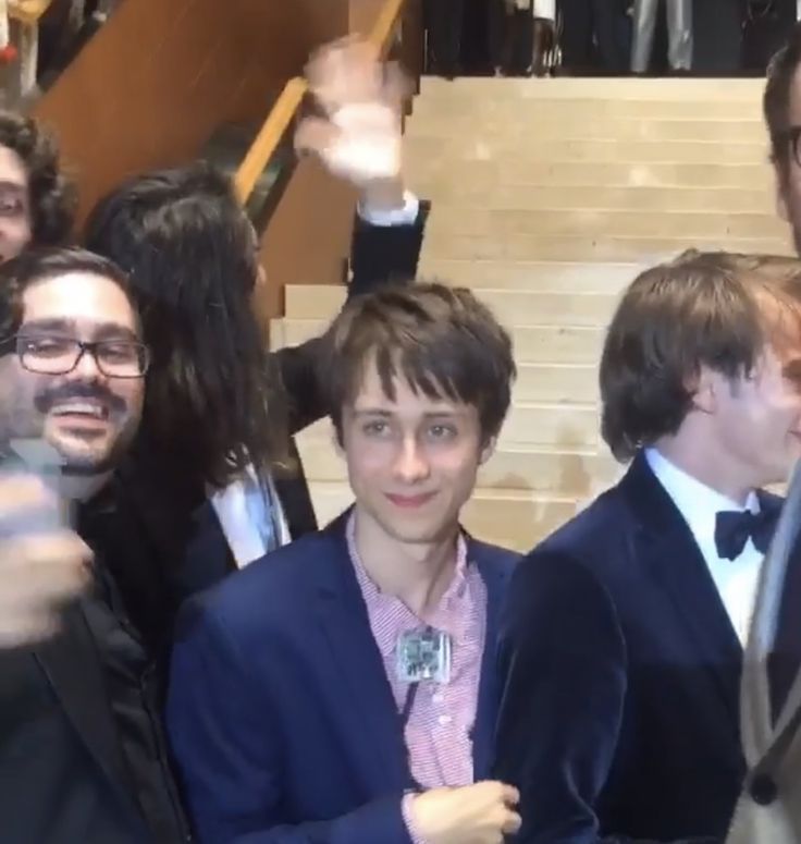 a group of young men standing next to each other in front of stairs and staircases