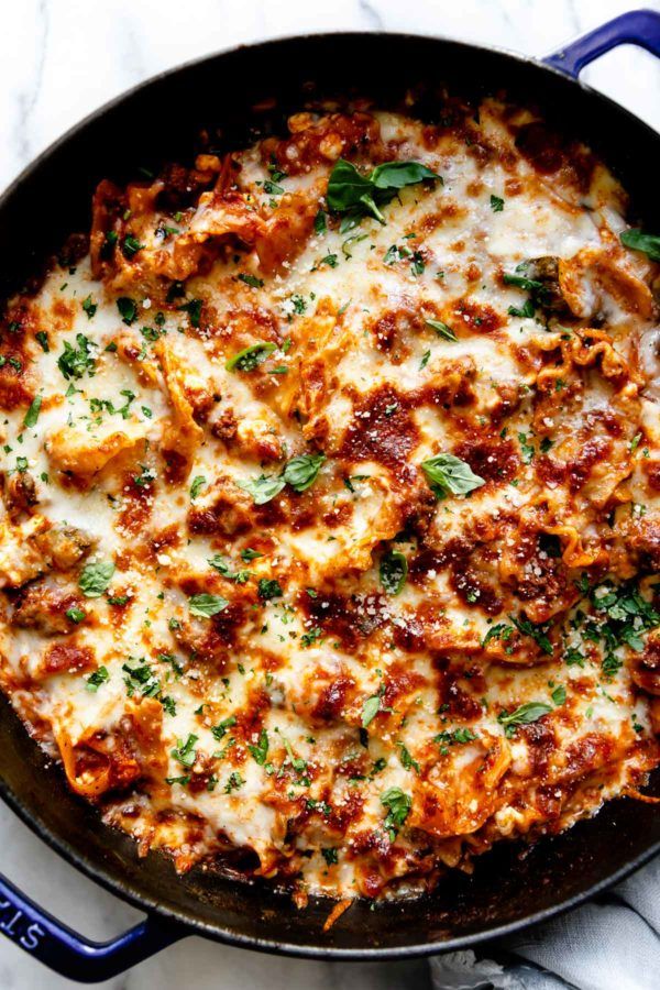 a skillet filled with cheese and meat covered in parmesan