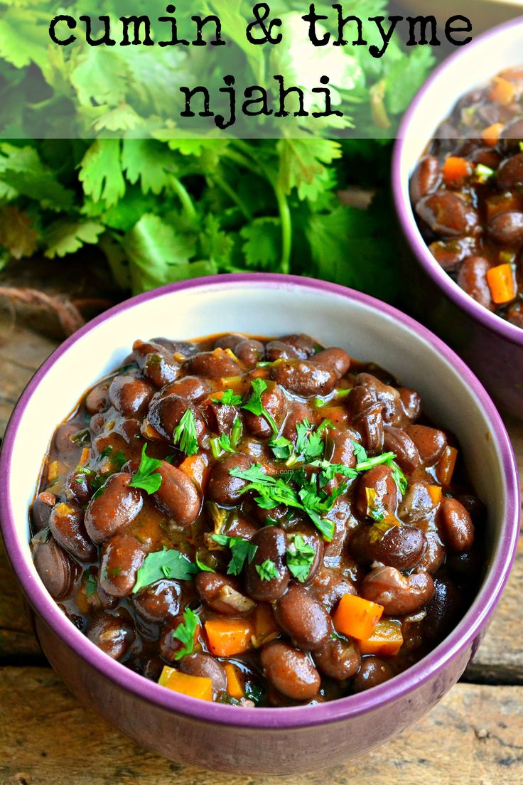 two purple bowls filled with black beans and carrots next to parsley on the side