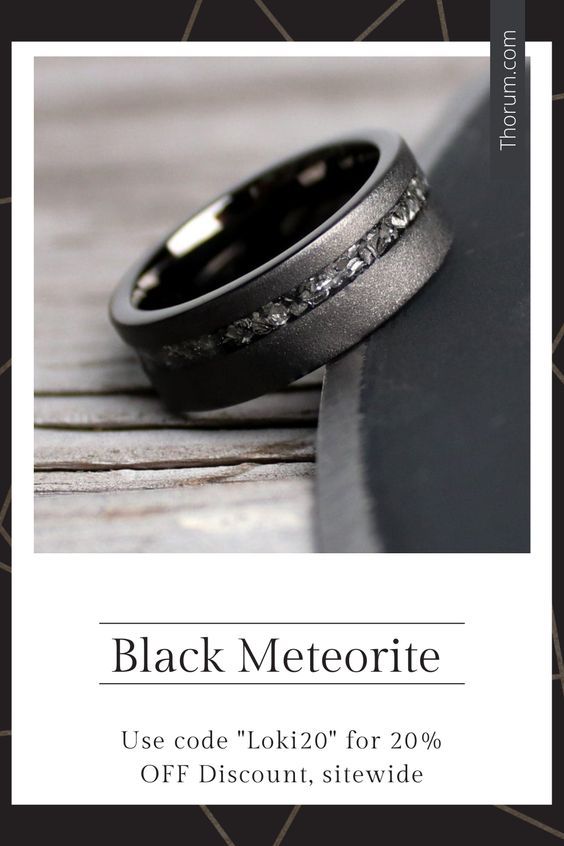 two wedding rings sitting next to each other on top of a wooden table with the words black meteorite