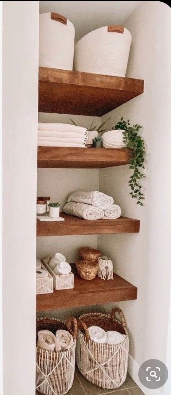 some shelves in a bathroom with baskets and towels