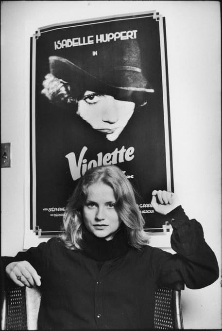 a woman sitting in front of a poster with the words violettte on it,