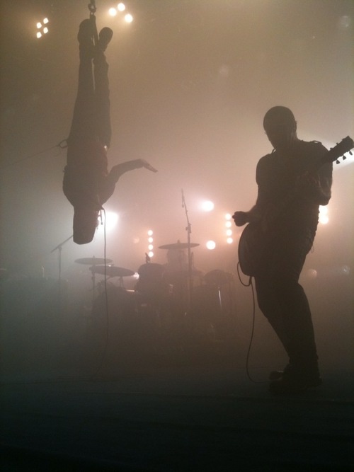 a man standing on top of a stage holding a guitar