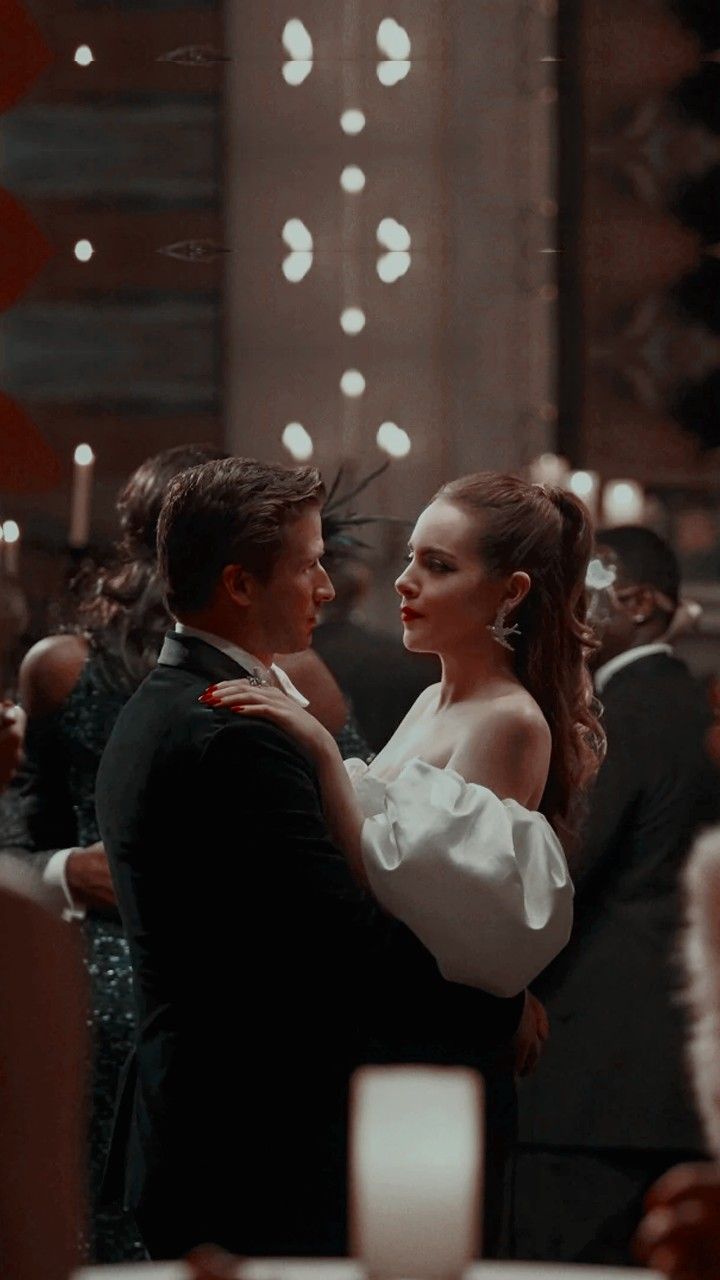 a man and woman dance together in front of an audience at a formal event with candles on the table