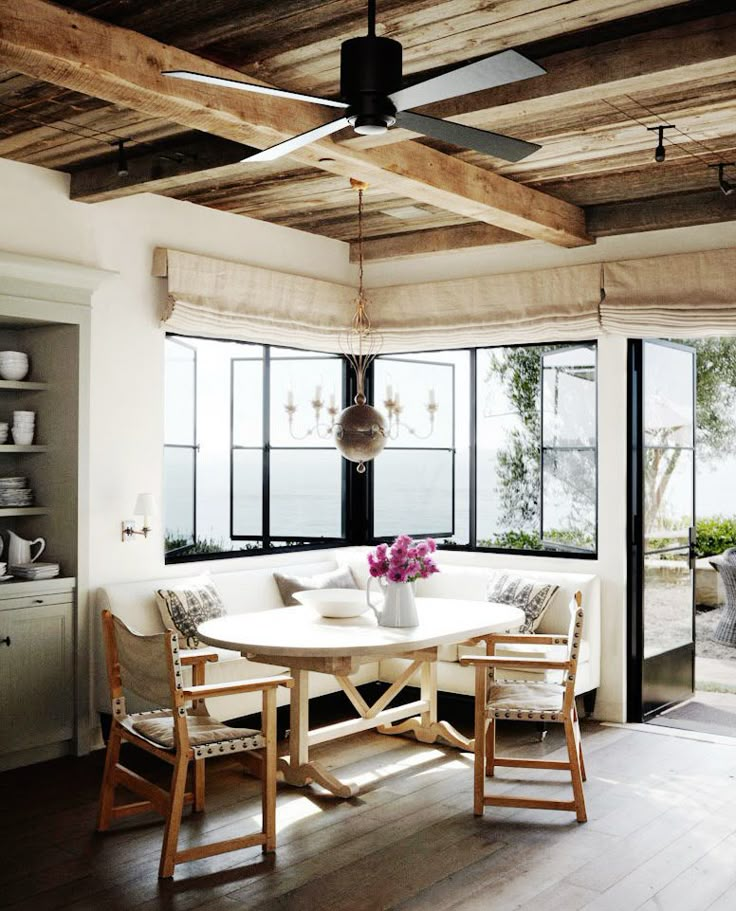 a dining room table with chairs and a ceiling fan in the middle of an open floor plan