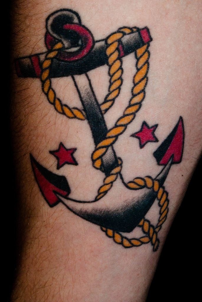 an anchor and rope tattoo on the arm