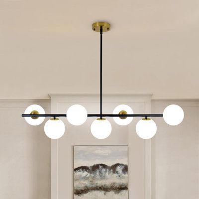 a modern chandelier hangs over a dining room table with chairs and a painting on the wall