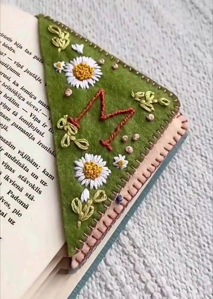 an open book with embroidered flowers on it