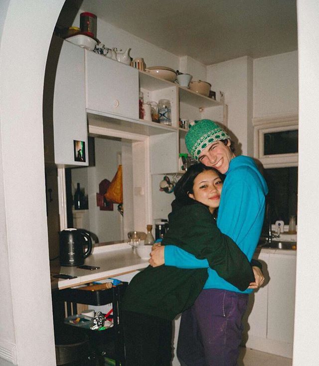 two people hugging each other in a kitchen