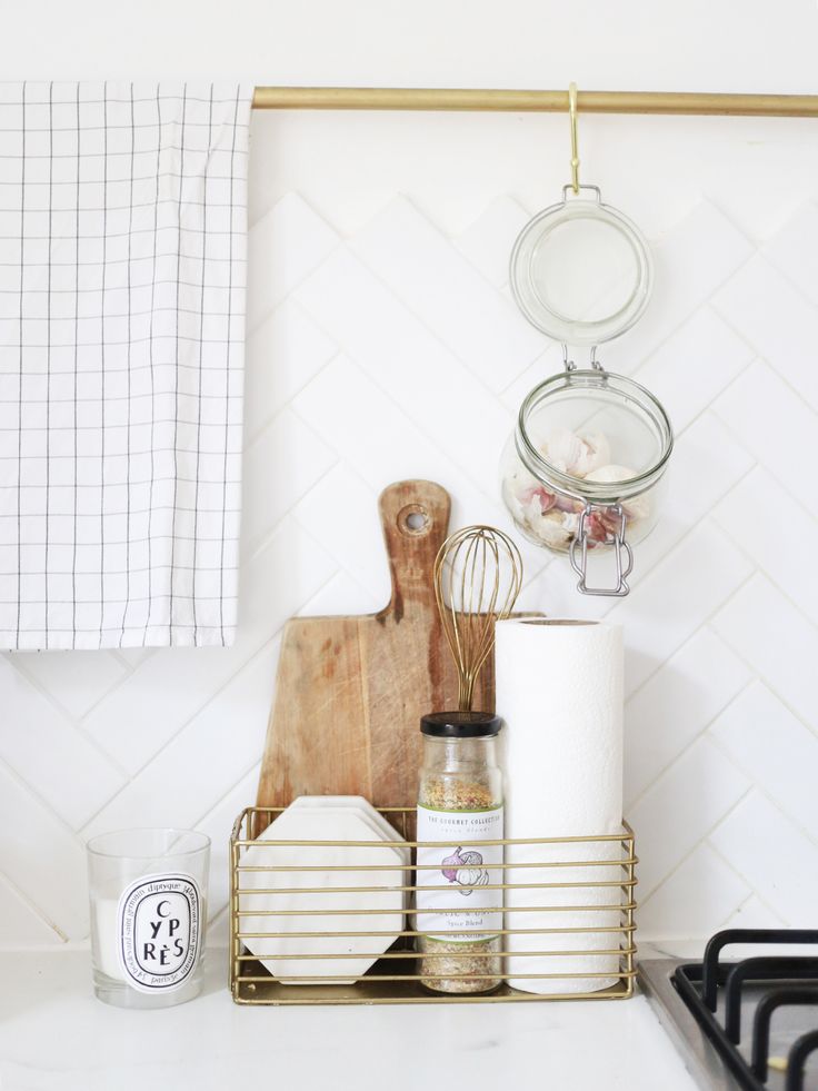 the kitchen counter is organized with white dishes and utensils