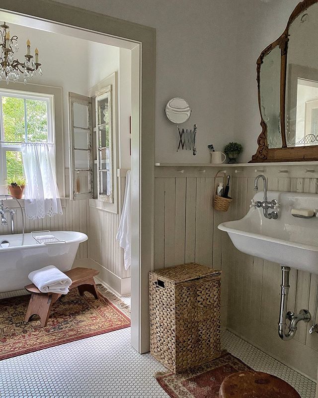 a bathroom with a claw foot tub, sink and mirror on the wall above it