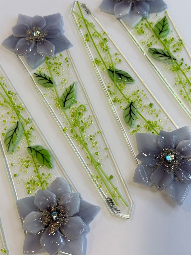 four flower shaped hair pins sitting on top of a table