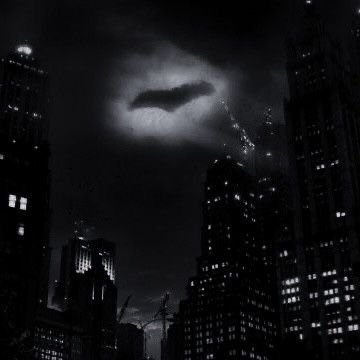 a black and white photo of a dark city at night with a flying object in the sky