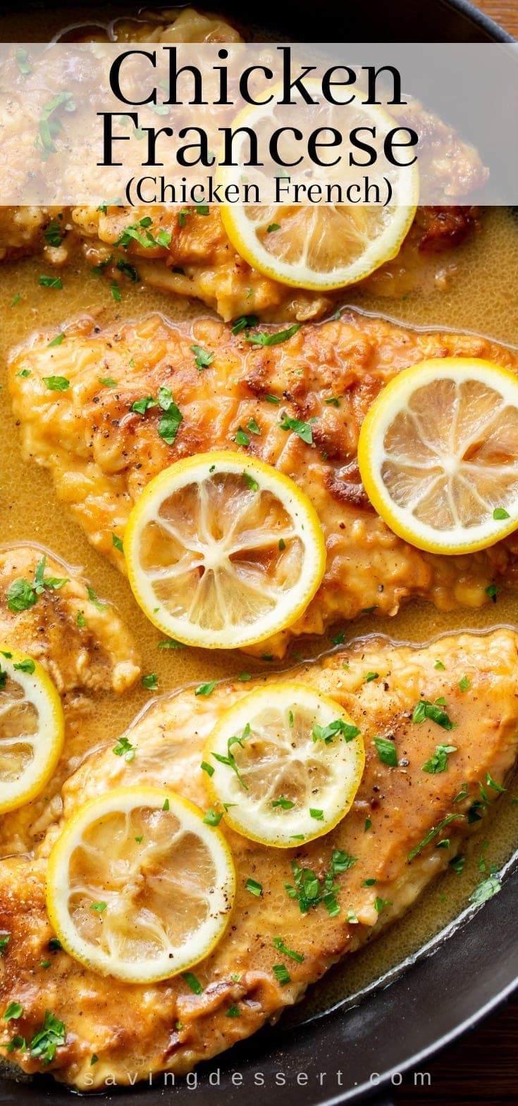 chicken francee with lemons and parsley on the side in a skillet