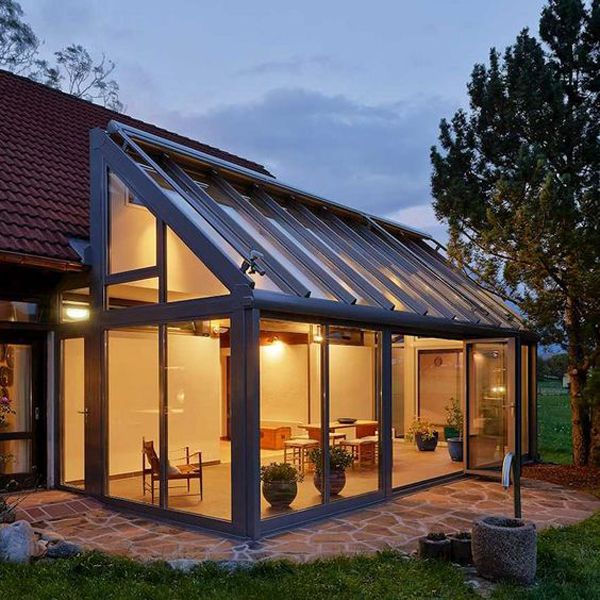 a house that is sitting in the grass with windows on it's sides and doors open