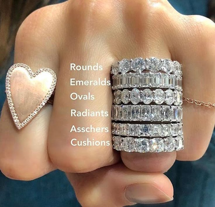 a person holding three different rings with their names in the middle and two heart shaped diamonds on