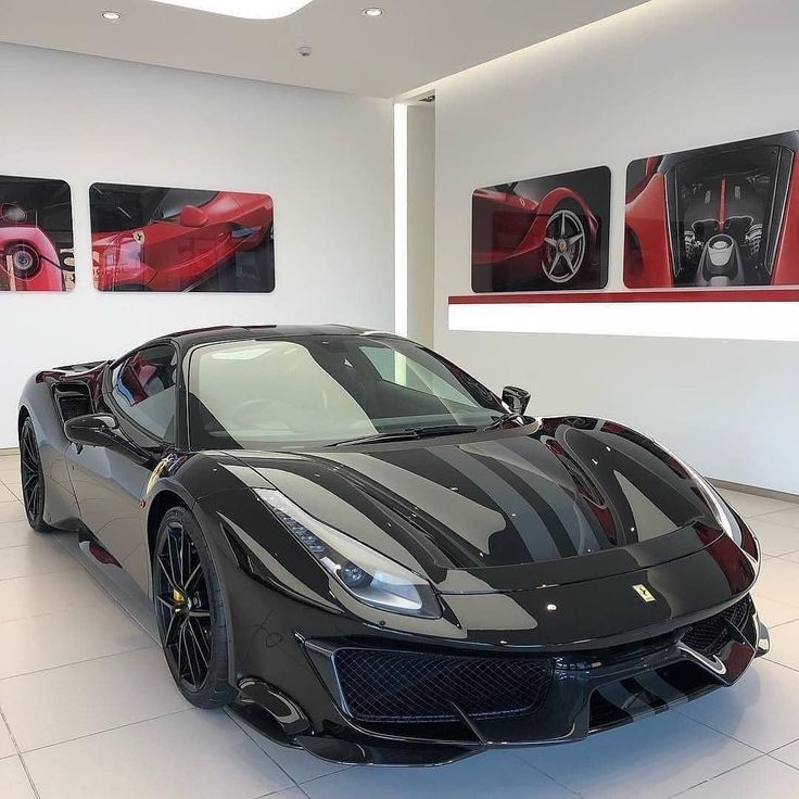 a black sports car in a showroom with pictures on the wall and flooring