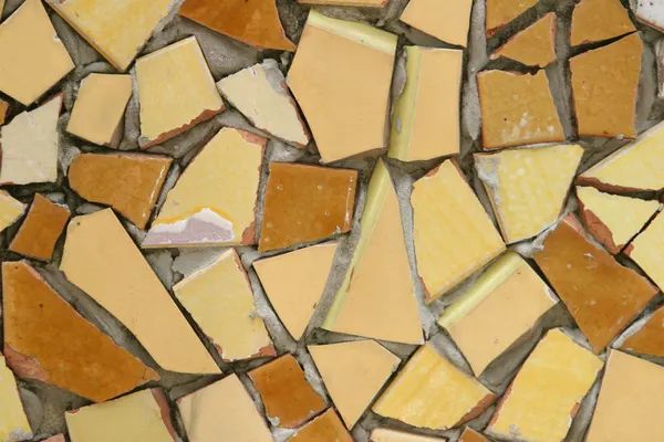 a close up view of yellow and brown mosaic tiles