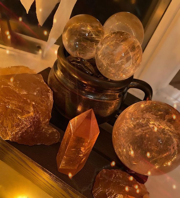 some glass balls are sitting on a table next to a vase with lights in it