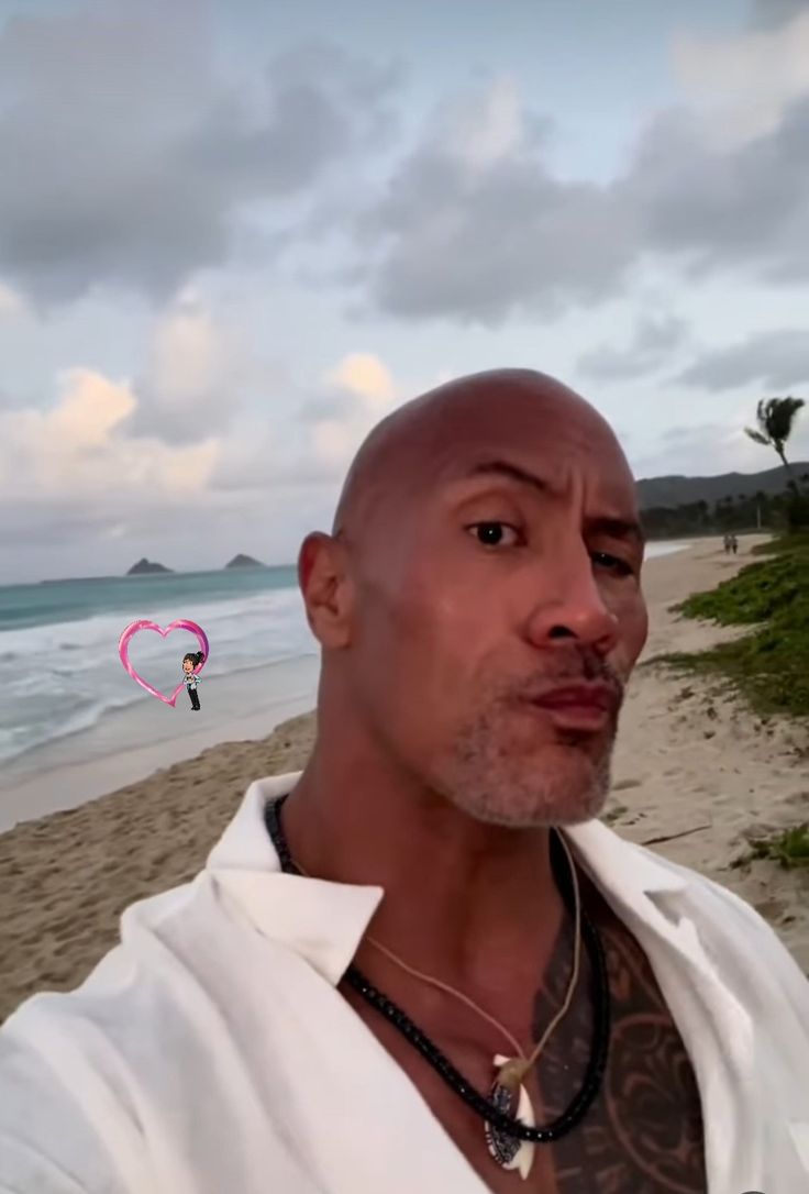 a man standing on top of a sandy beach next to the ocean