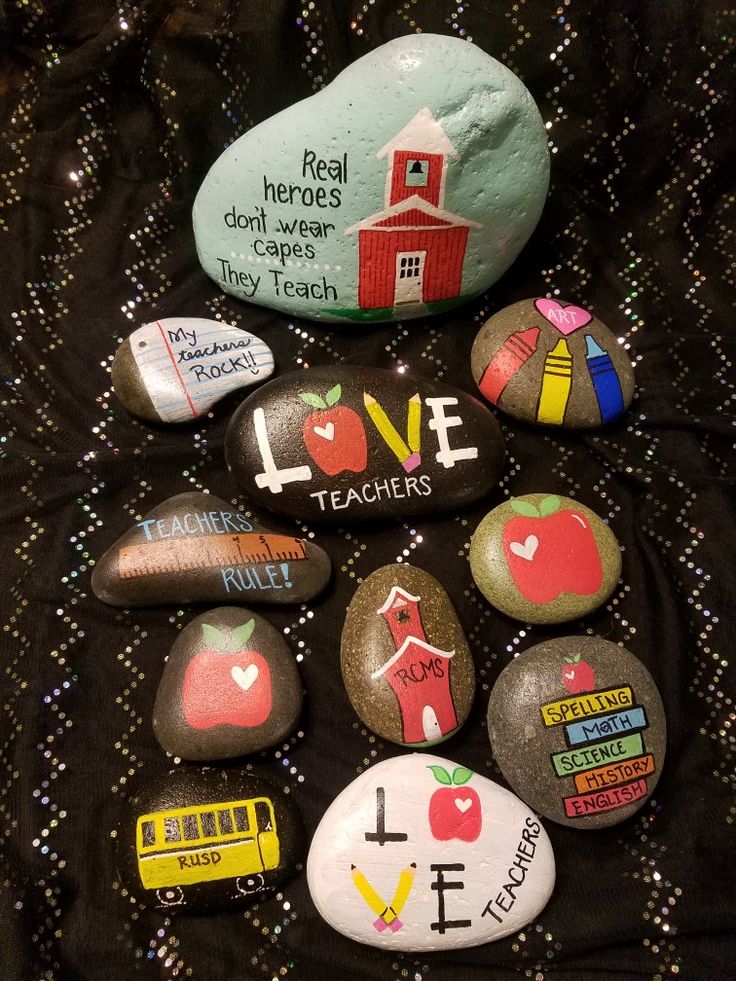 some rocks with different designs and words on them are arranged in the shape of a heart