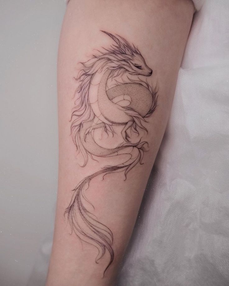 a woman's arm with a dragon tattoo on it