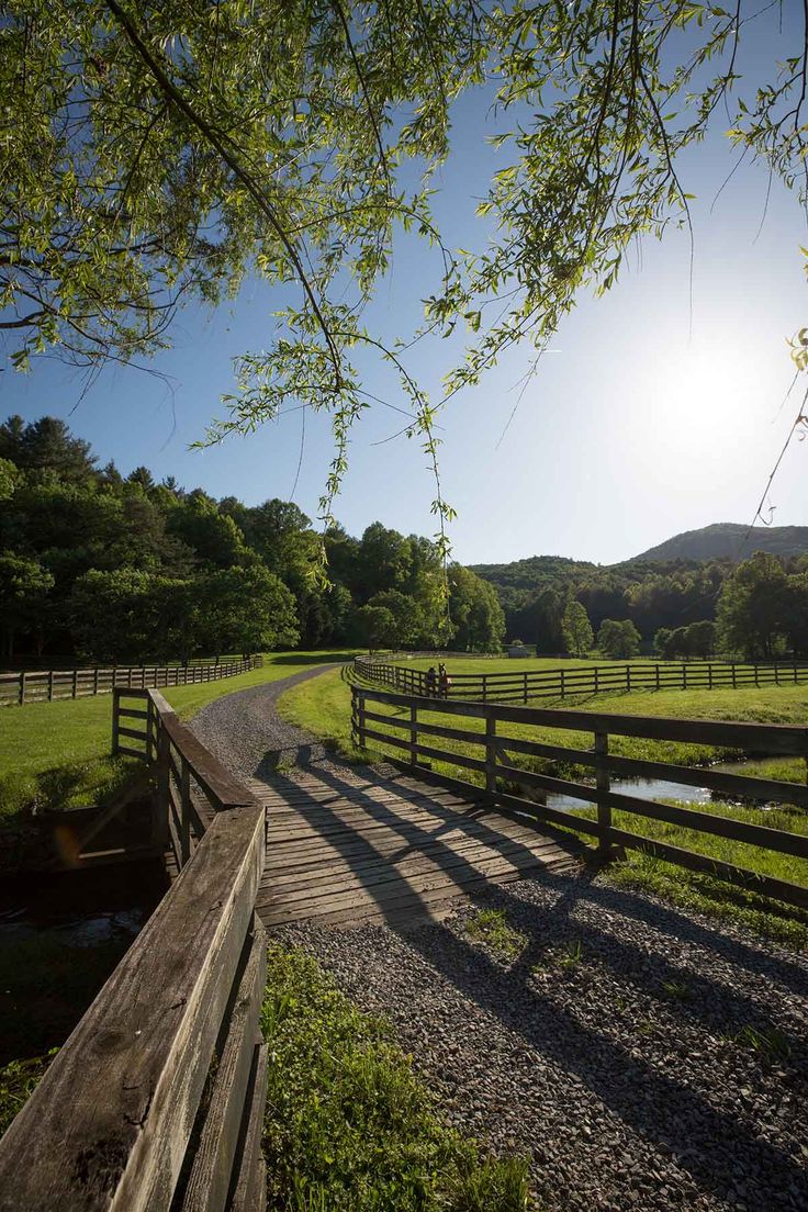 the sun is shining over a fenced in field