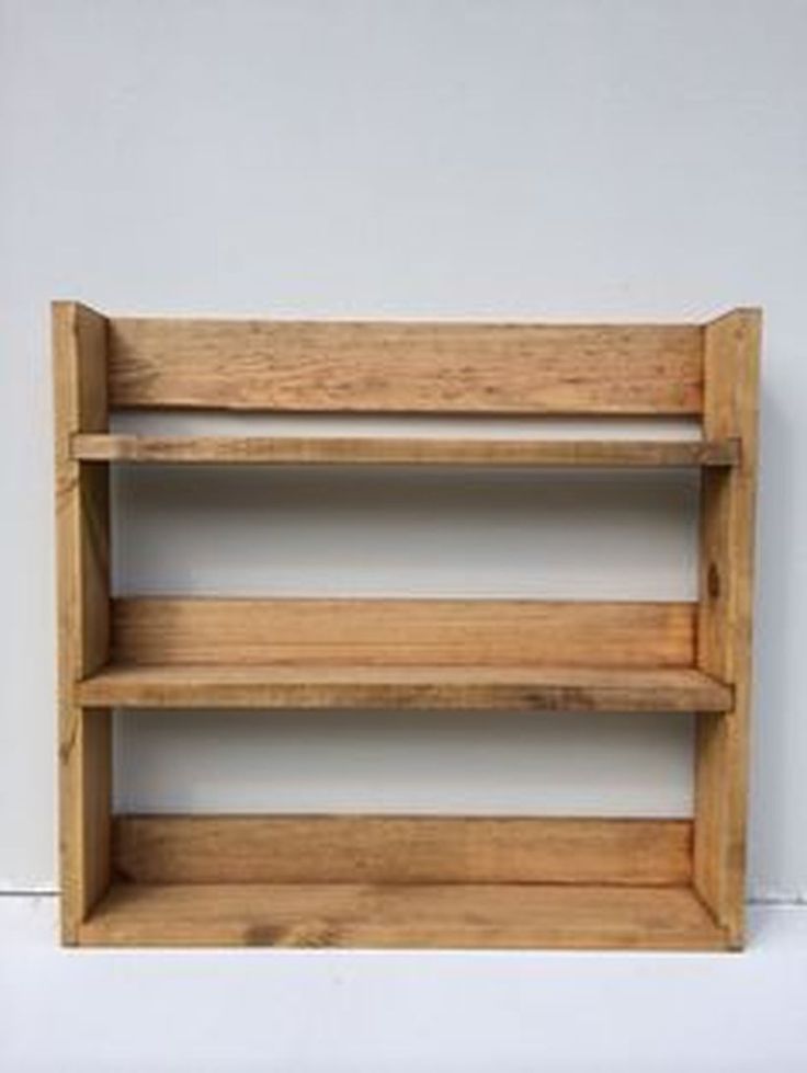 an empty wooden shelf against a white wall