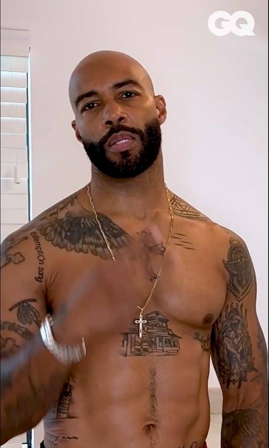 a shirtless man with tattoos on his chest