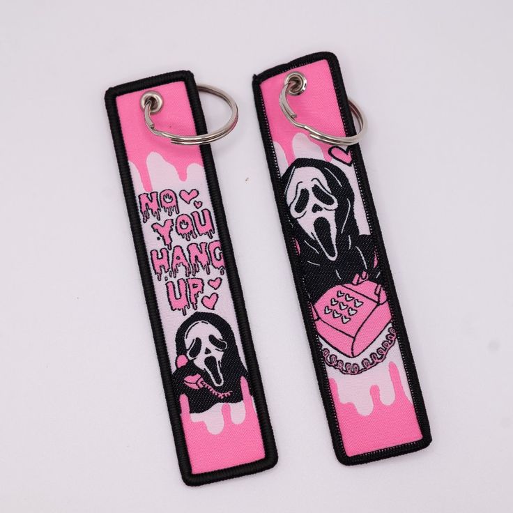 two pink and black key chains with the words do you hang up? on them