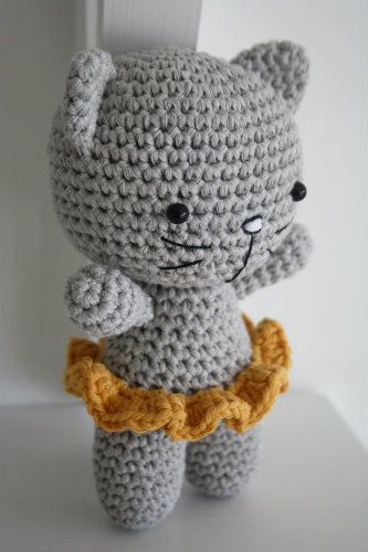 a crocheted gray cat with a yellow bow around its neck