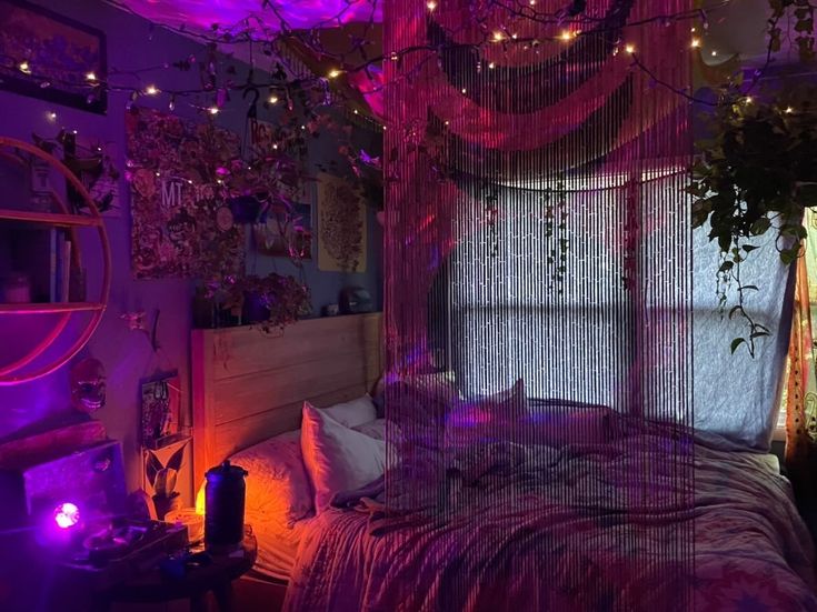 a bed with purple lights and curtains hanging from the ceiling