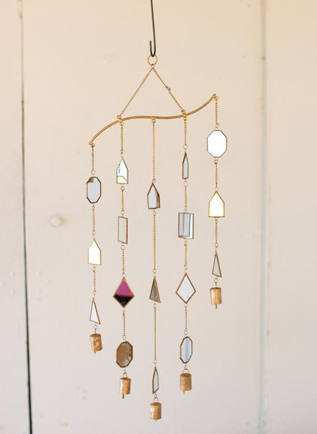 a wind chime hanging from the side of a wall with different shapes and colors