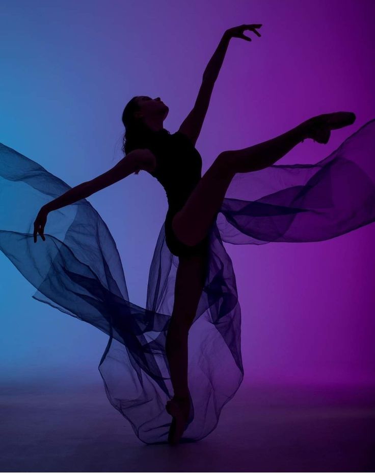 a woman in a black leotard is dancing with purple and blue lights behind her