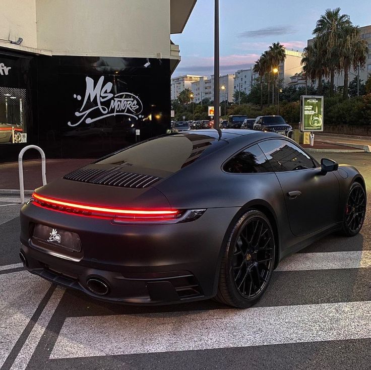 a black sports car parked in front of a building