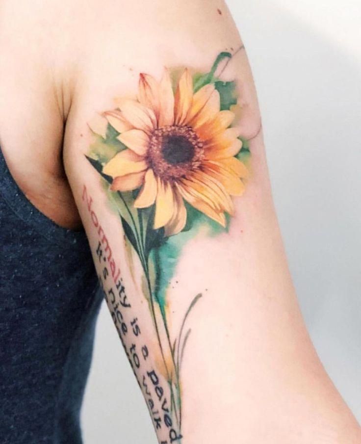 a woman's arm with a sunflower tattoo on it