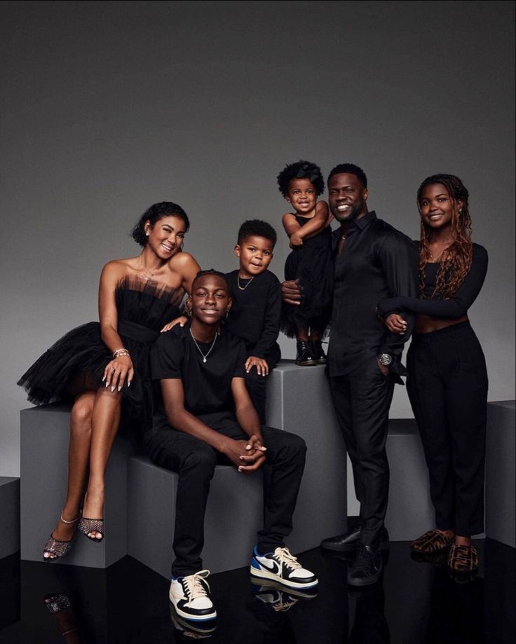 a group of people are posing for a photo in front of a gray background and black backdrop