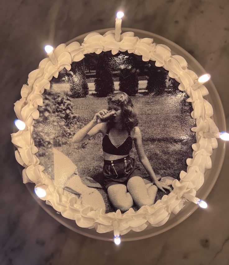 a birthday cake with an image of a woman sitting on the ground in front of it