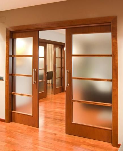 an empty room with wooden floors and glass doors