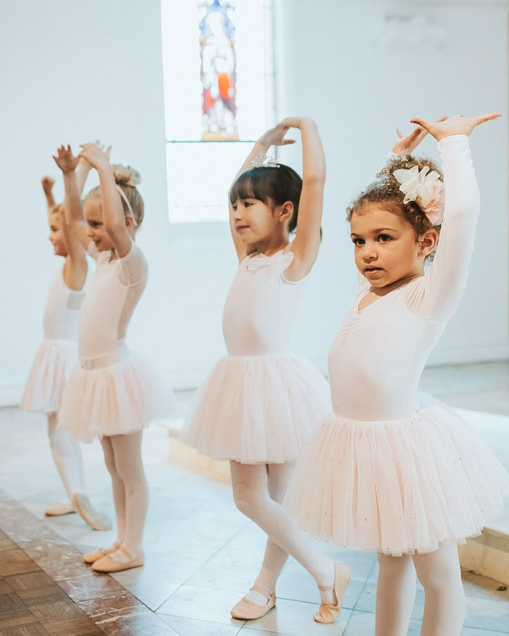 three young ballerinas in pink tutus and leotards