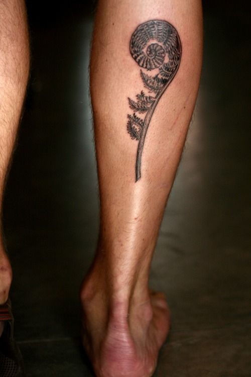 a close up of a person's foot with a flower tattoo on the leg