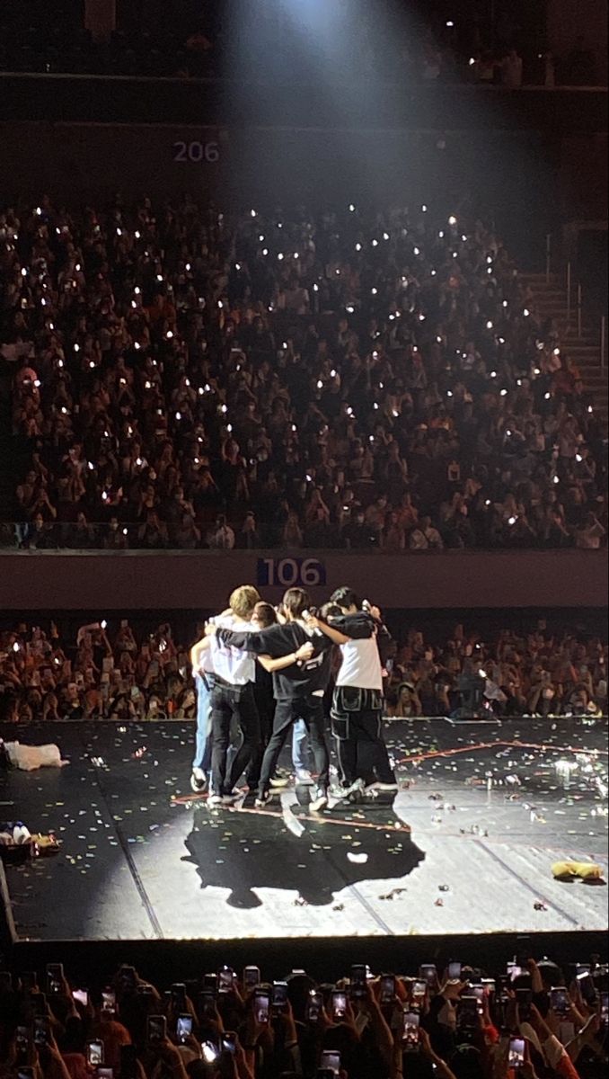 a group of people standing on top of a stage surrounded by confetti and streamers