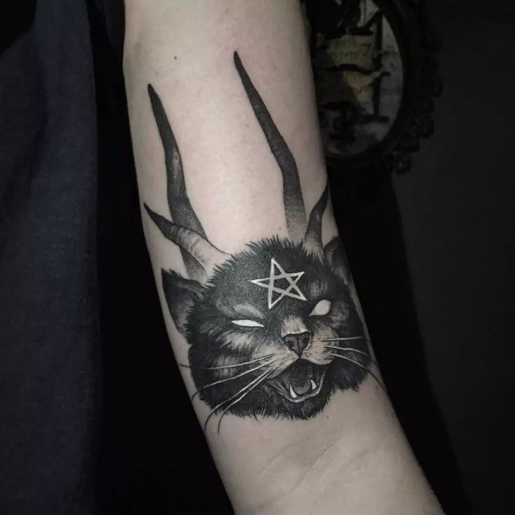 a black and white photo of a cat with horns on it's head tattoo