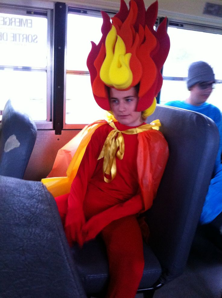 a young boy dressed as a firebird sitting in the back seat of a bus